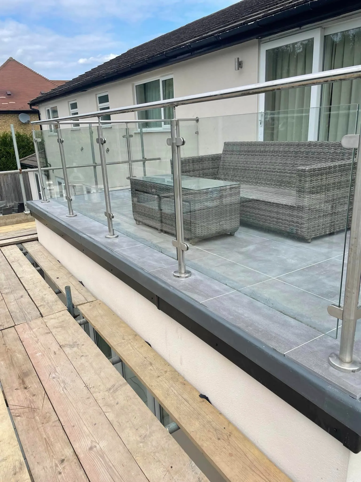 A balcony with a couch and chair on it.